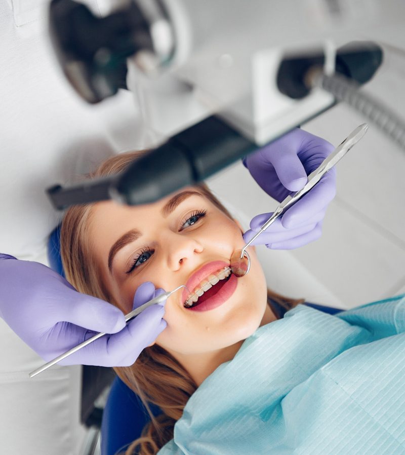 Beautiful girl sitting in the dentist’s office Beautiful lady in the dentist's office. Woman in a uniform