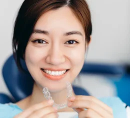 closeup_woman_putting_in_clear_retainer_at_dentist-1311280330